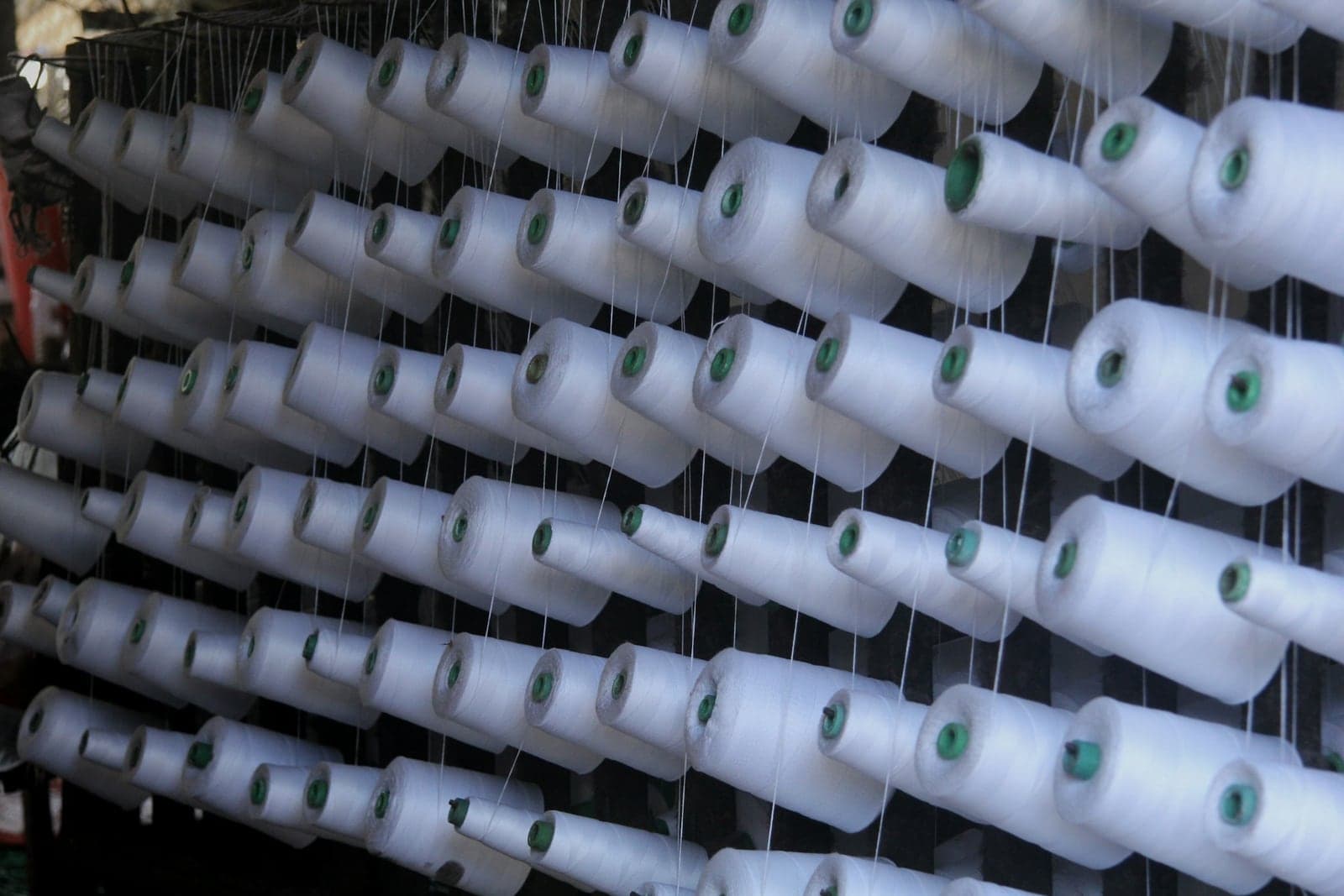 Rows of white yarn cones on a mill rack