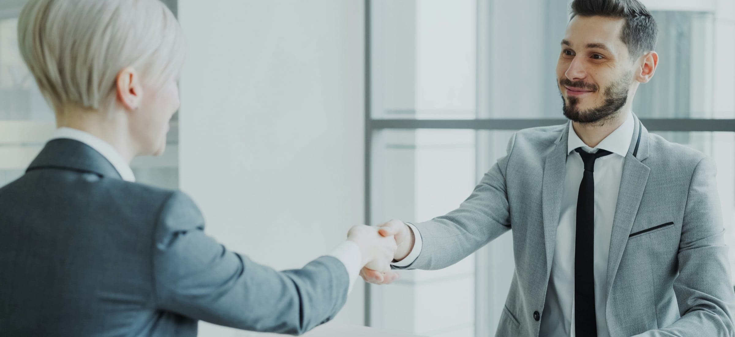 Two professionals shaking hands across a table