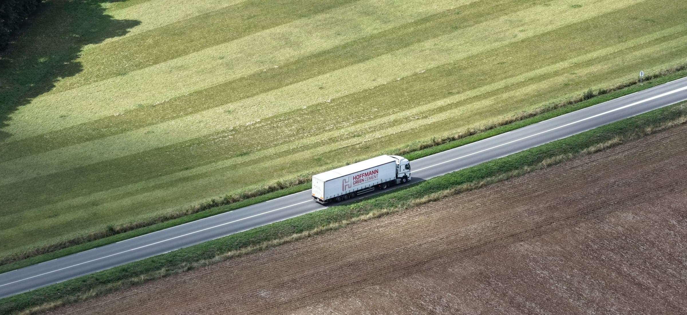 A freight truck on a highway running through farmland